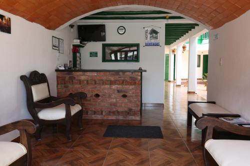a living room with a brick fireplace and chairs at Esquina Colonial in Villa de Leyva