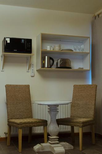 two chairs and a table in a kitchen with a microwave at ALEHUE Casa de Montaña in Villa La Angostura