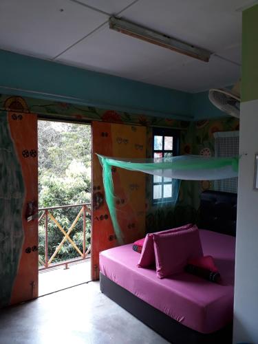 - une chambre avec un lit rose et une grande fenêtre dans l'établissement Fatehah Inn, à Kuala Tahan