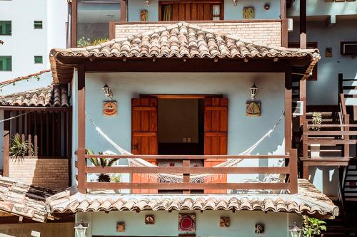 a small house with a porch and a balcony at Pousada Alice in Cabo Frio