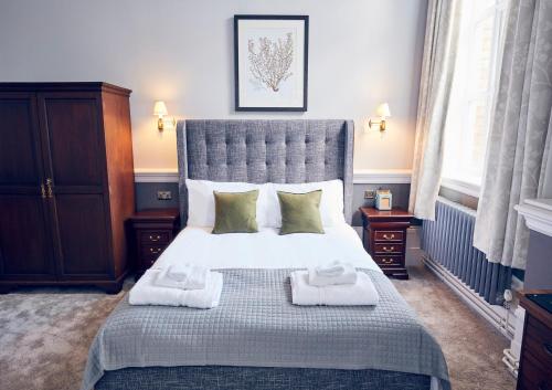 a bedroom with a large bed with towels on it at The Old Coffee Tavern in Warwick