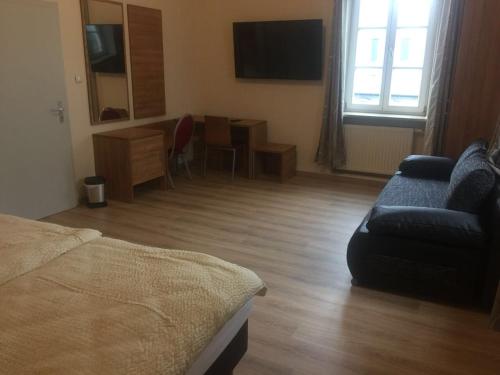 um quarto com uma cama, um sofá e uma mesa em Jujhar's Gästehaus em Wasserburg am Inn