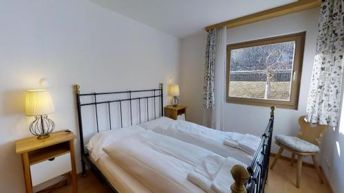 una camera da letto con un letto e una finestra di Pavrella a Celerina