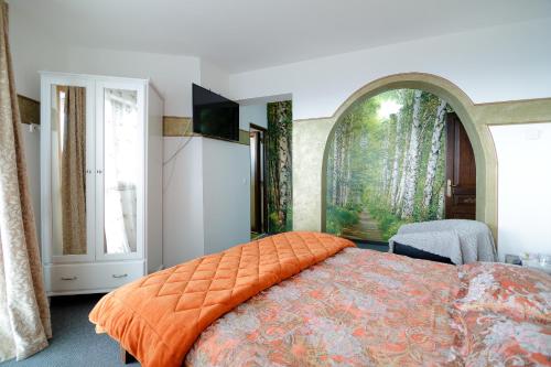 ein Schlafzimmer mit einem großen Bett und einem orangefarbenen Kissen in der Unterkunft Casa Dacilor Liberi in Ranca