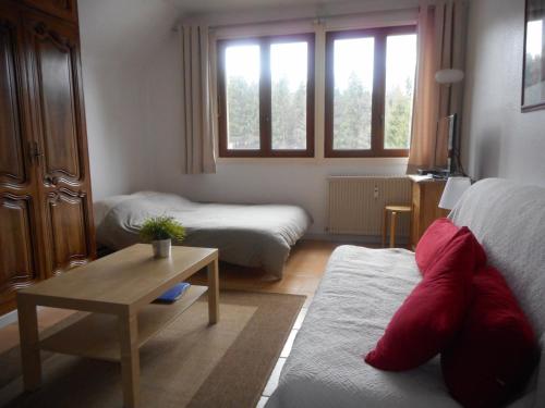ein Wohnzimmer mit 2 Betten und einem Tisch in der Unterkunft la Charbonnière in Bellefosse