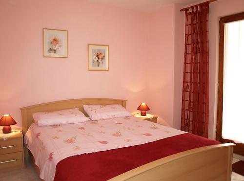 ein Schlafzimmer mit einem Bett, zwei Lampen und einem Fenster in der Unterkunft Apartmani Pergola in Kukljica