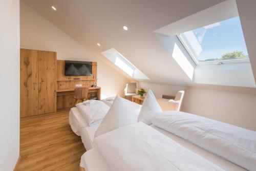 a attic bedroom with two white beds and a skylight at Hotel & Gasthaus Löwen in Waldkirch