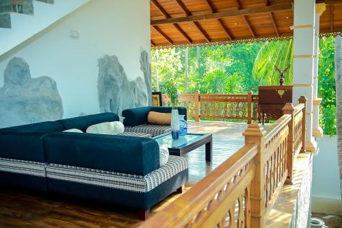 a living room with a couch and a table on a porch at Morning Star in Mirissa