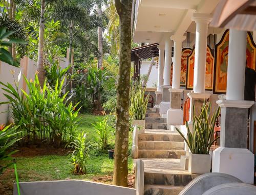 a building with stairs and plants in a yard at Morning Star in Mirissa