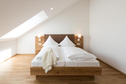 a bedroom with a bed with white sheets and pillows at Hotel & Gasthaus Löwen in Waldkirch
