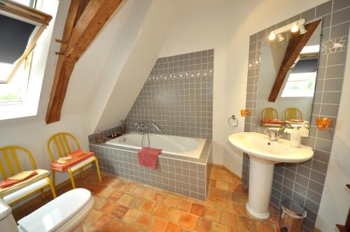 a bathroom with a tub and a sink and a toilet at Grange du Plessis in Segré