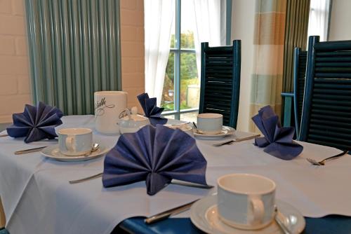 a table with blue napkins and cups on it at Pension zum Brauhaus in Stralsund