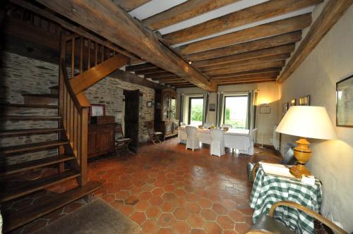a living room with a staircase and a table and chairs at Grange du Plessis in Segré
