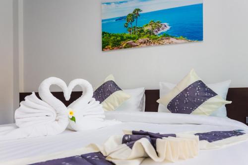 dwa łabędzie zrobione z ręczników siedzące na dwóch łóżkach w obiekcie The Retreat Khaolak Resort - SHA Extra Plus w mieście Khao Lak