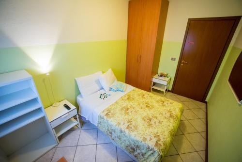 a small bedroom with a bed and a night stand at Adria Bella Locazione Turistica in Adria