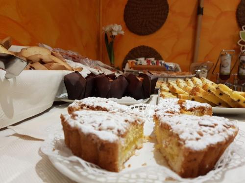 a table topped with different types of bread and desserts at Hotel Piccolo Lido in Bordighera