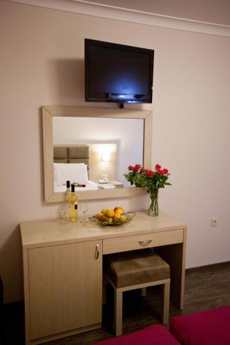 a table with a mirror and a bowl of fruit on it at Filokalia Hotel in Ioannina