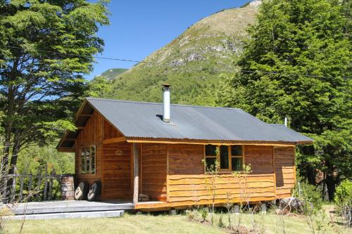 a log cabin with a mountain in the background at Cabañas Sol de Montañas in Futaleufú