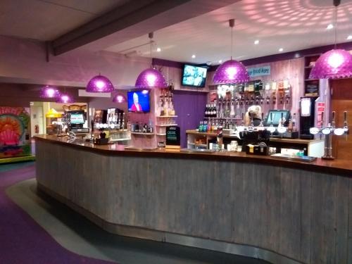 a bar in a restaurant with purple lights at Newquay View Hideaway in Newquay