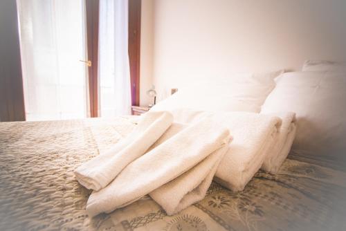 a white bed with two towels on top of it at RELAX locazione turistica in Ceregnano