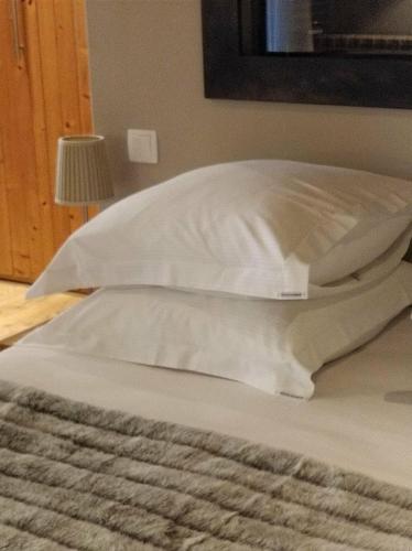 a bed with two white pillows on top of it at Clos Masure hôtel de campagne in Belmesnil