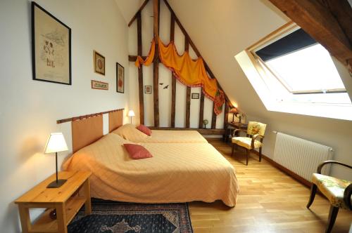 a bedroom with a bed and a large window at Grange du Plessis in Segré