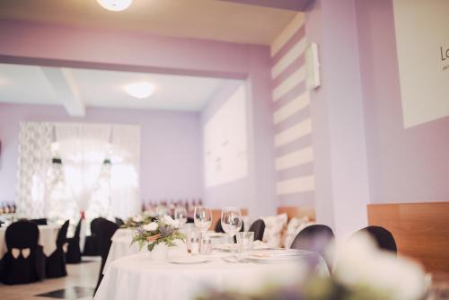 une salle à manger avec des tables et des chaises blanches dans l'établissement Hotel Elite, à Salsomaggiore Terme