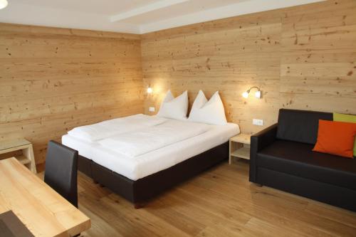 Habitación de hotel con cama y sofá en Appartements Mutschlechner en Valdaora