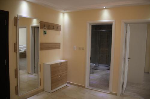 a bathroom with a toilet and a sink and mirrors at Golden Dunes Primorsko Apartments in Primorsko