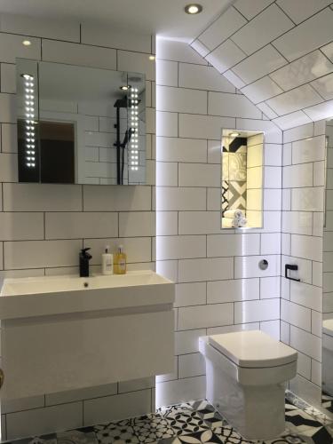 a white bathroom with a toilet and a sink at 23 Mayfield in Edinburgh