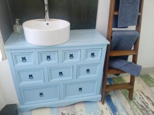 - une commode bleue avec un lavabo et une chaise dans l'établissement L'ancienne École, à Geay