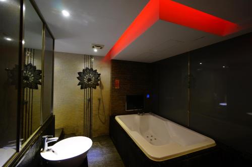 y baño con bañera, lavamanos y bañera. en 荷村 Motel en Wuqi