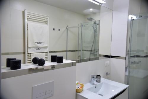 a white bathroom with a sink and a shower at Apartamenty Platan Opieszyn in Września