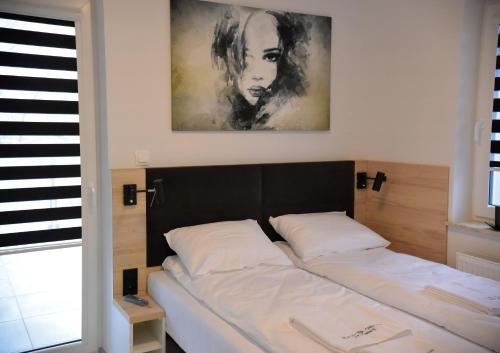 - un lit avec 2 oreillers blancs dans une chambre dans l'établissement Apartamenty Platan Opieszyn, à Września