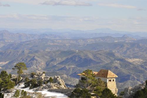 a building on a hill with mountains in the background at Casas Rurales Tio Frasquito y Cleto in Yeste