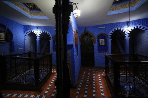 a blue room with blue walls and black doors at Dar Lbakal in Chefchaouene