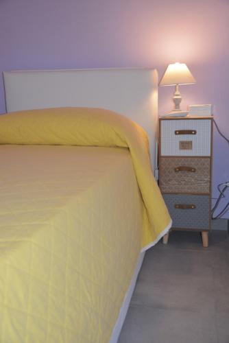 チェファルにあるCasello villa sul mare a Cefalù 59+866のベッドルーム1室(ベッド1台、ナイトスタンド、ランプ付)