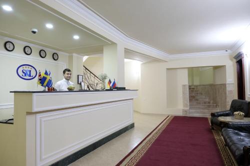 a man standing at a bar in a lobby at S&L Boutique Hotel in Tbilisi City
