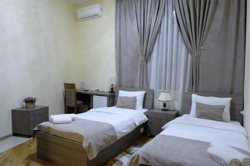 a bedroom with two beds and a desk in it at S&L Boutique Hotel in Tbilisi City