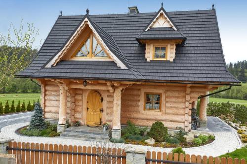 a small log cabin with a black roof at Osada Maruszyna in Szaflary