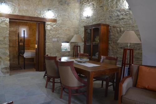 uma sala de jantar com uma mesa de madeira e cadeiras em Xenia 2 em Ayios Therapon
