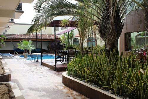 a courtyard with a table and chairs and a palm tree at Hotel Dubrovnik in Mérida