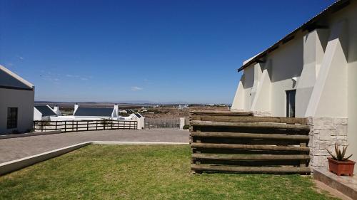 a house with a wooden fence next to a yard at Oppikoppie Langebaan in Langebaan