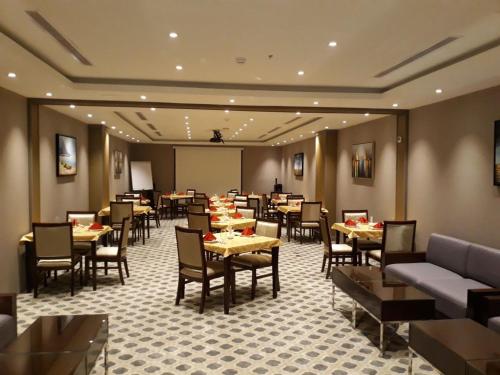 - un restaurant avec des tables et des chaises dans une salle dans l'établissement Beach Inn, à Al Qunfudhah