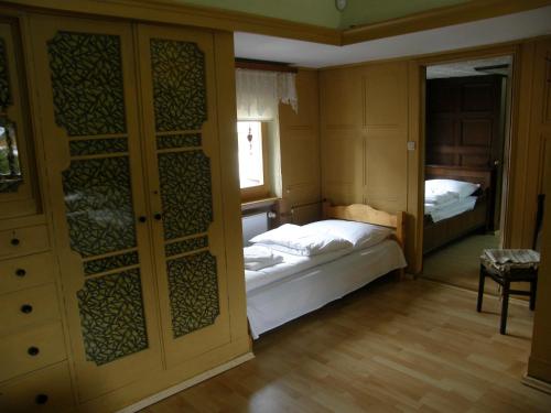 um pequeno quarto com uma cama e uma janela em Dom jak dawniej em Szklarska Poręba