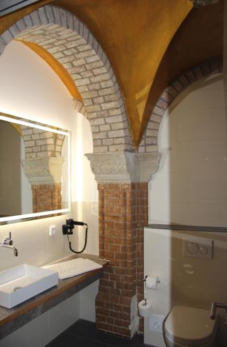 a bathroom with a sink and a refrigerator at AKZENT Hotel Villa Saxer in Goslar