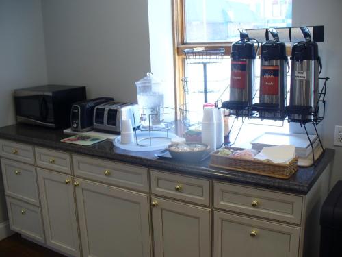 a kitchen counter with a counter top with a microwave and appliances at Villager Motel & Glen Manor Estate in Watkins Glen