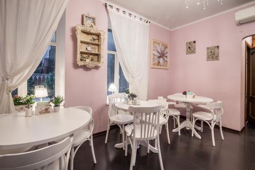 a dining room with white tables and chairs and a window at Blues in Saint Petersburg