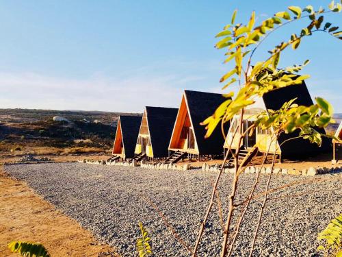 a group ofolithicolithicolithicolithicolithicolithicolithicolithic houses on a hillside at Ixchel Glamping Valle de Guadalupe in Ensenada