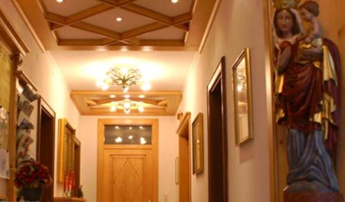 a hallway with a door and a statue of a woman at Pension Bergfried in Grödig